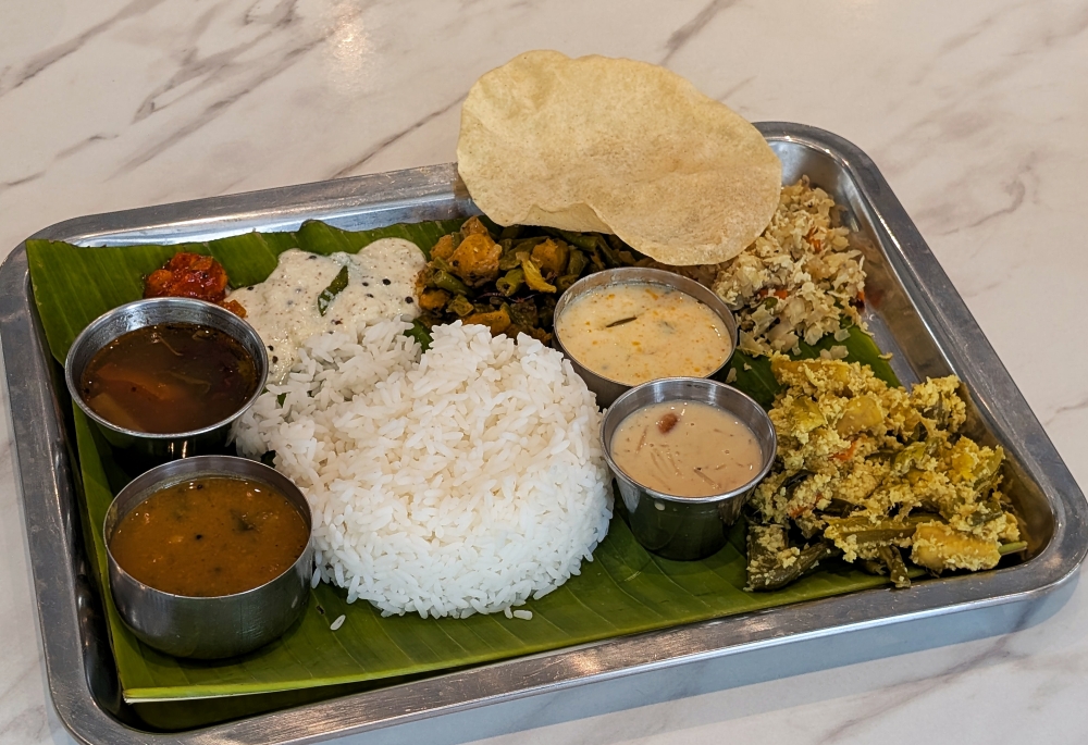 The vegetarian meal is a lunch staple, and comes with three types of vegetable dishes, pickle, ‘pachadi’, ‘rasam’, ‘sambar’, ‘mooru’ and ‘payasam’ to finish. — Picture by Ethan Lau