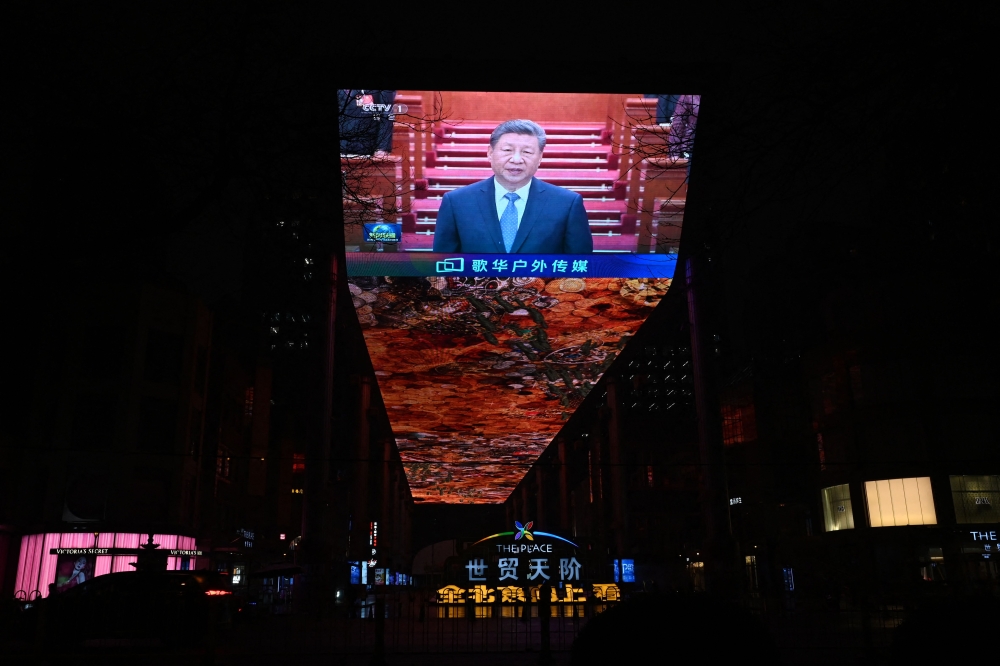 A large screen outside a shopping mall shows news coverage of Chinese President Xi Jinping attending the opening ceremony of the Chinese People’s Political Consultative Conference in Beijing’s Great Hall of the People on March 4, 2026. — AFP pic