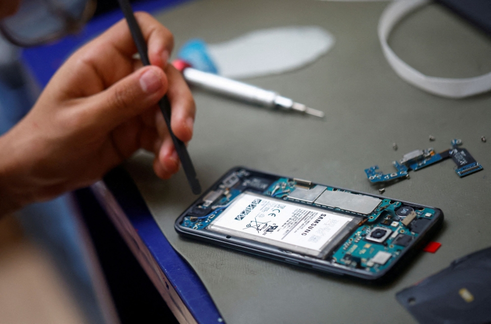 A smartphone repair technician works on a Samsung Electronics’ Galaxy S8 in Saint-Sebastien-sur-Loire, near Nantes. South Korea’s chip industry is worried that the Iran crisis could disrupt supplies of some key chip-making materials like helium from the Middle East. — Reuters pic