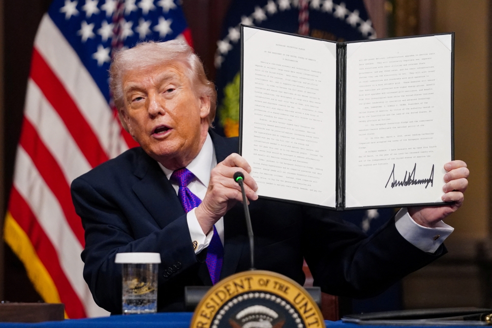 US President Donald Trump shows a signed document as he attends a roundtable on the Ratepayer Protection Pledge in the Indian Treaty Room at the Eisenhower Executive Office Building in Washington, DC on March 4, 2026. — Reuters pic