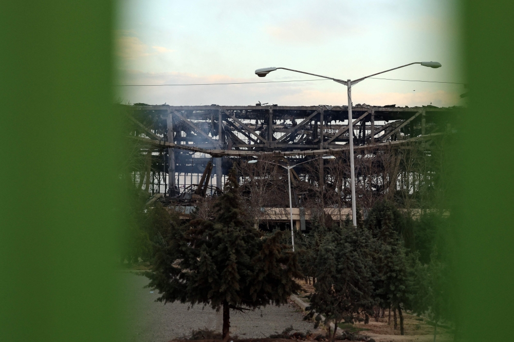 A photograph taken through a fence shows a heavily damaged building at Tehran's Azadi Sport Complex following a strike on March 5, 2026. — AFP pic