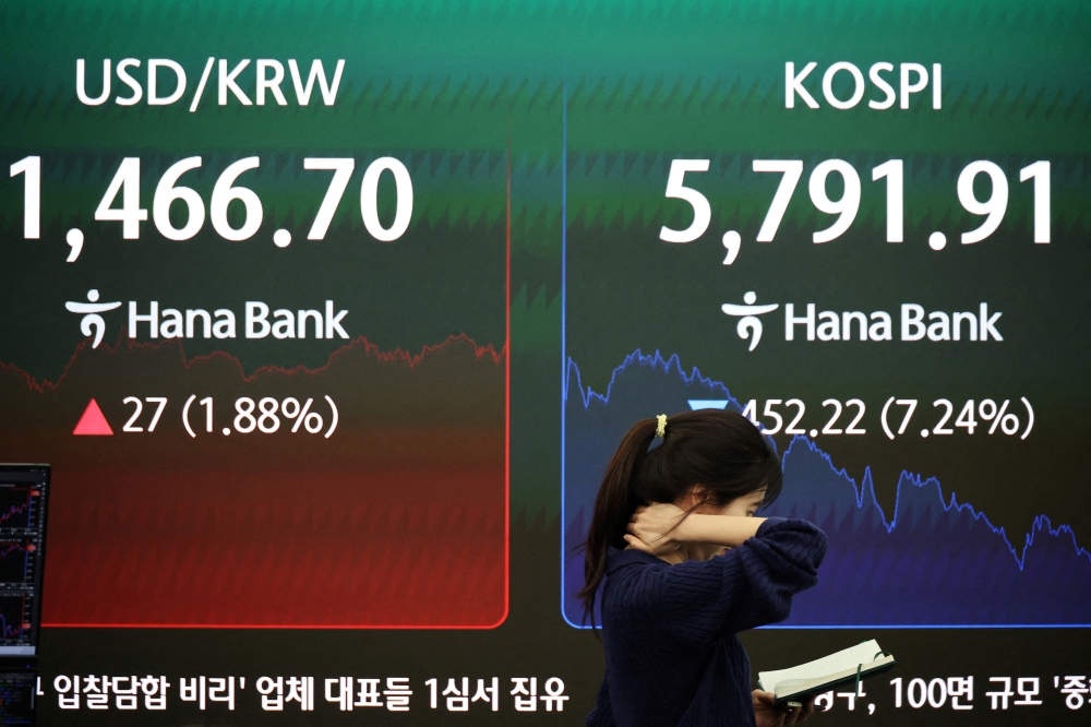 A currency dealer walks past an electronic board displaying the Korea Composite Stock Price Index (Kospi) and the exchange rate between the US dollar and the South Korean won at the dealing room of a bank in Seoul March 3, 2026. — Reuters pic 