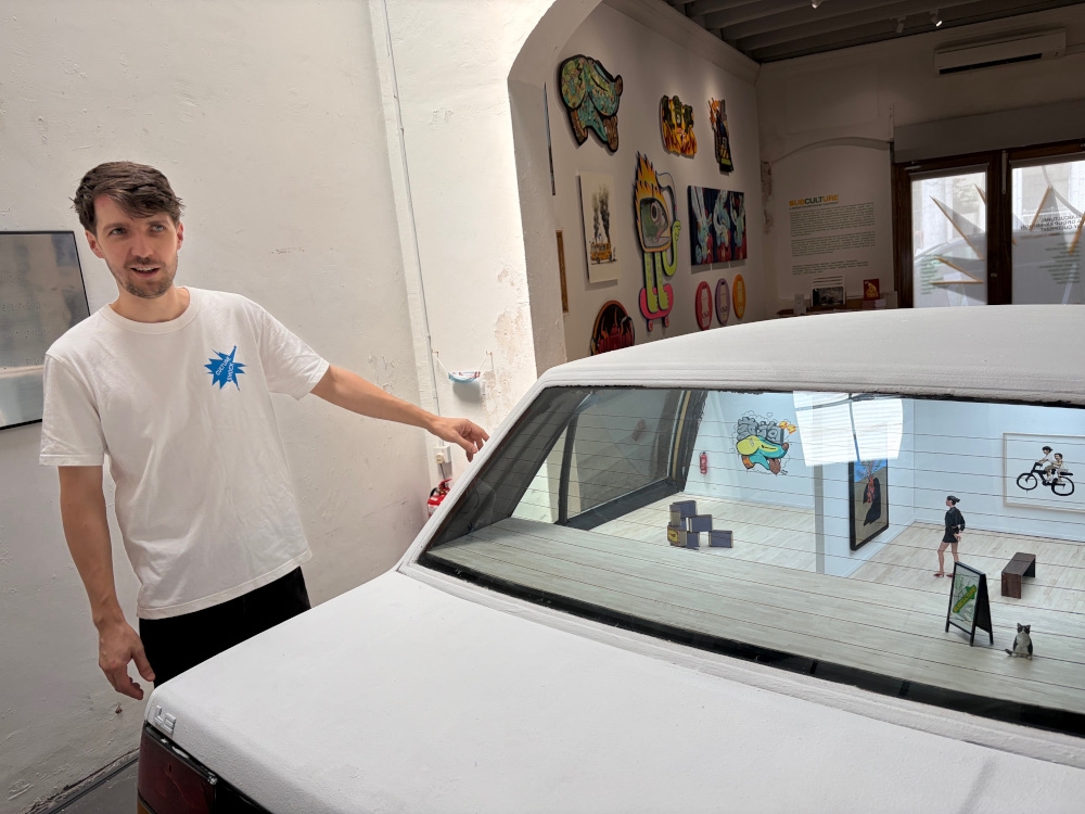 Cultprint co-founder Ernest Zacharevic explaining the concept of the car gallery. — Picture by Opalyn Mok