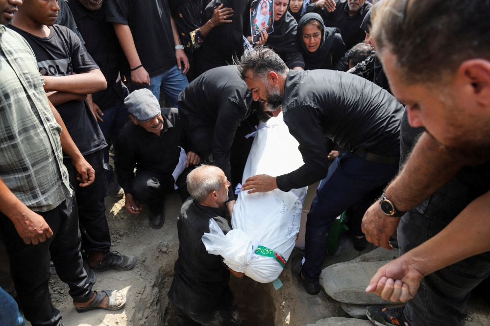 People prepare the body for a burial as they attend the funeral of the victims following a reported strike on a school, amid the US-Israeli conflict with Iran, in Minab, Iran, March 3, 2026. — Amirhossein Khorgooei/ISNA/WANA (West Asia News Agency) handout pic via Reuters 