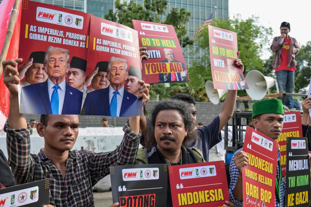Demonstrators hold placards, including two (L) claiming that Indonesia's President Prabowo Subianto and Vice President Gibran Rakabuming Raka are puppets of the US, during a demonstration condemning US and Israeli attacks on Iran and Palestinians in front of the US Embassy in Jakarta on March 3, 2026. — AFP pic 