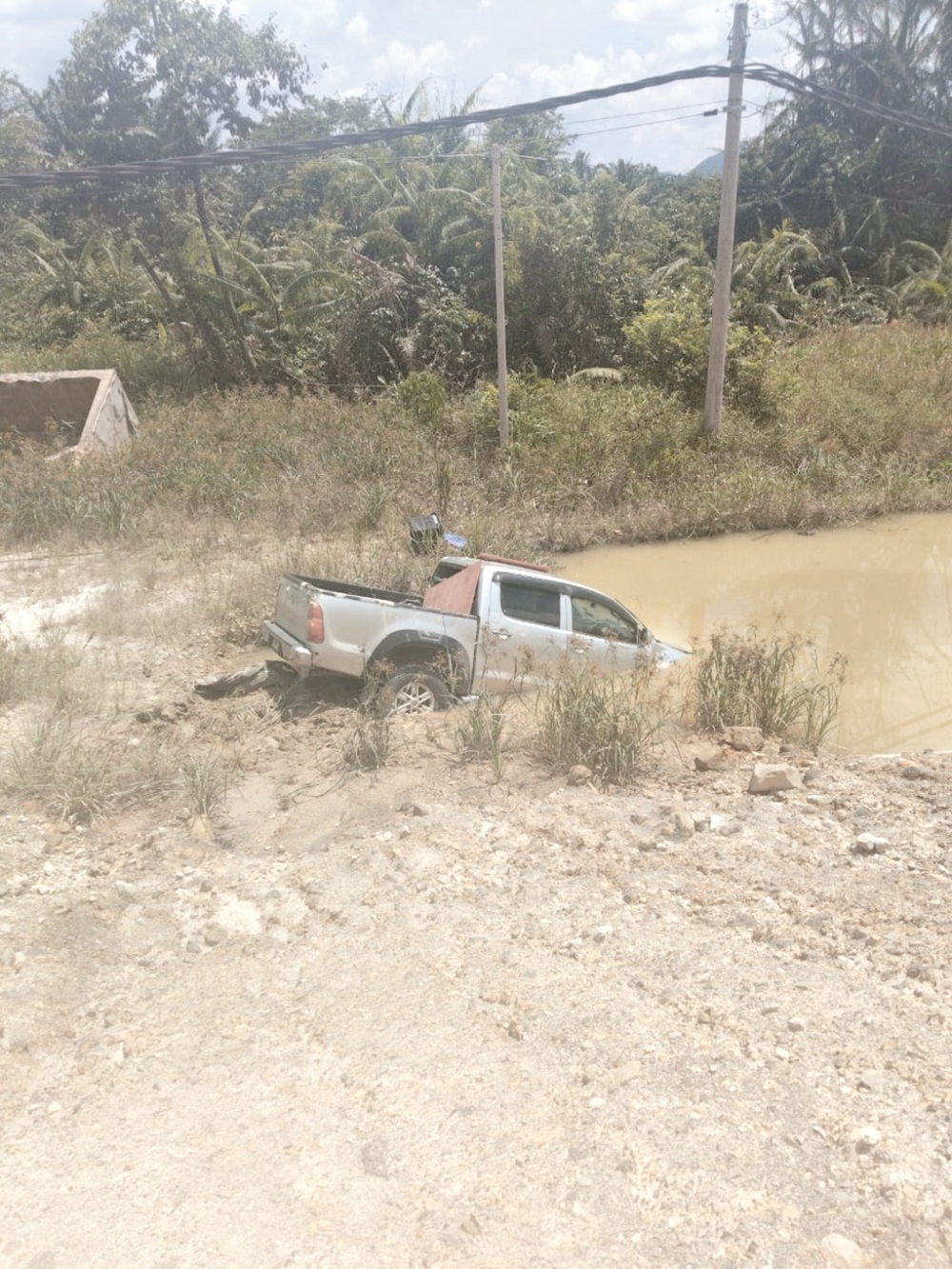 The 4WD vehicle that skidded into a water-filled drain in Beaufort. — Daily Express pic