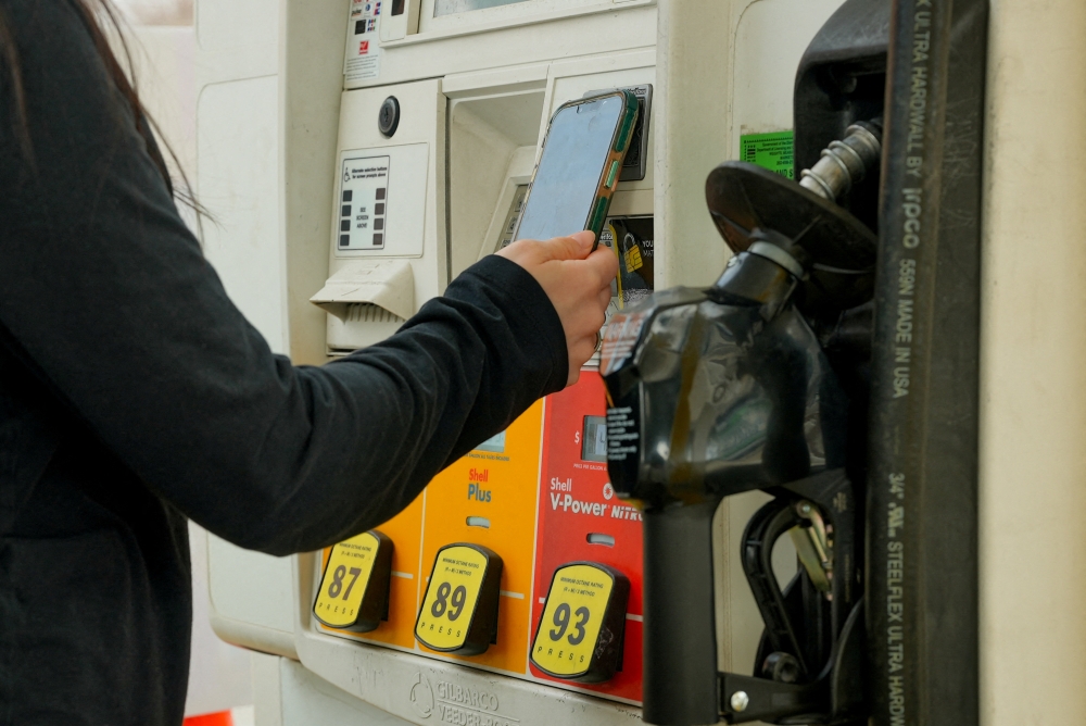 A woman pays for gas at a Shell station in Washington, DC on March 5, 2026. — Reuters pic