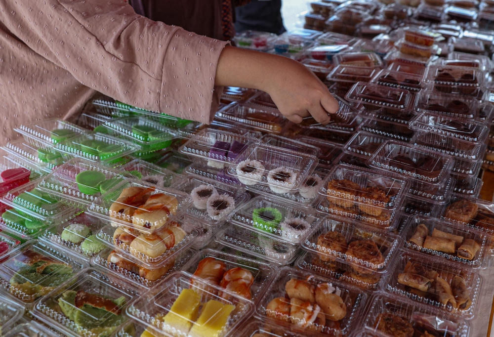 A trader arranges packets of kuih for sale at a bazaar. Deputy Entrepreneur and Cooperatives Development Minister Datuk Mohamad Alamin said the RM1 million project aims to provide organised business space for local micro-entrepreneurs. — Bernama pic