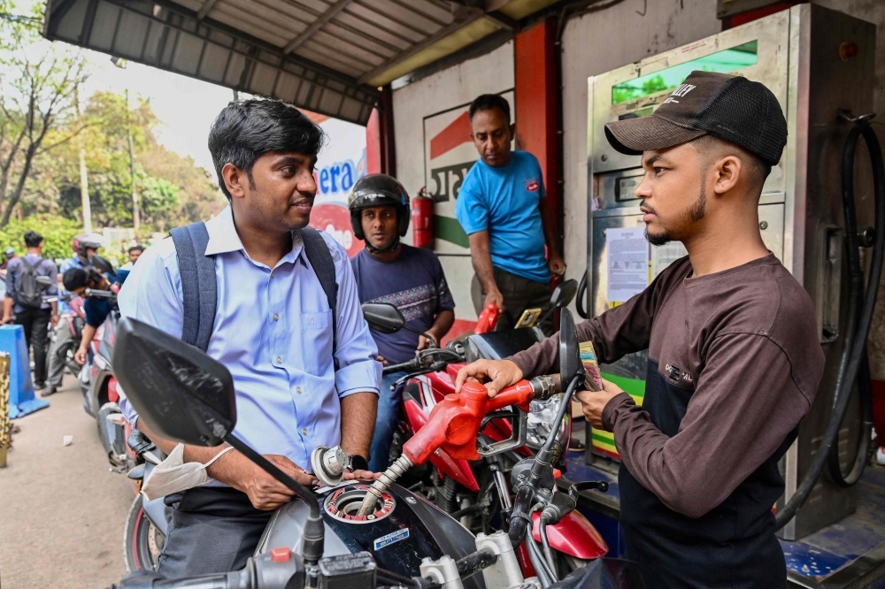 A man gets his motorcycle refueled at a fuel station in Dhaka on March 8, 2026. — AFP pic