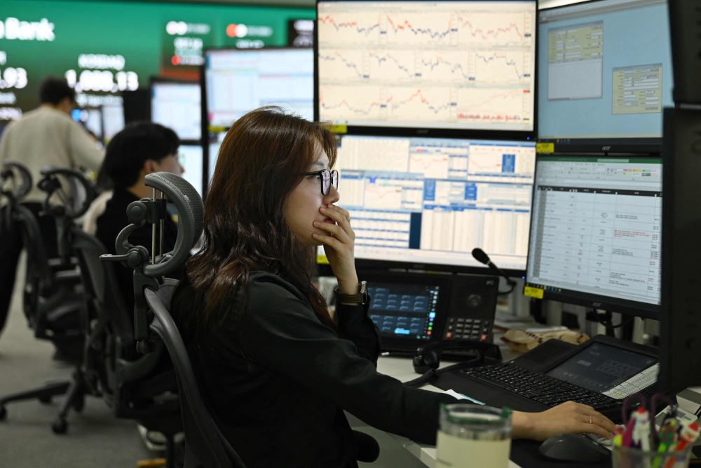 Currency dealers monitor exchange rates in a foreign exchange dealing room at the Hana Bank headquarters in Seoul on March 4, 2026. — AFP pic 