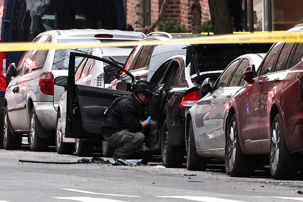 A NYPD bomb squad officer checks the inside of a car on the Upper East Side of Manhattan after a homemade explosive device thrown yesterday near anti-Muslim protesters failed to detonate, in New York, on March 8, 2026. — AFP pic 