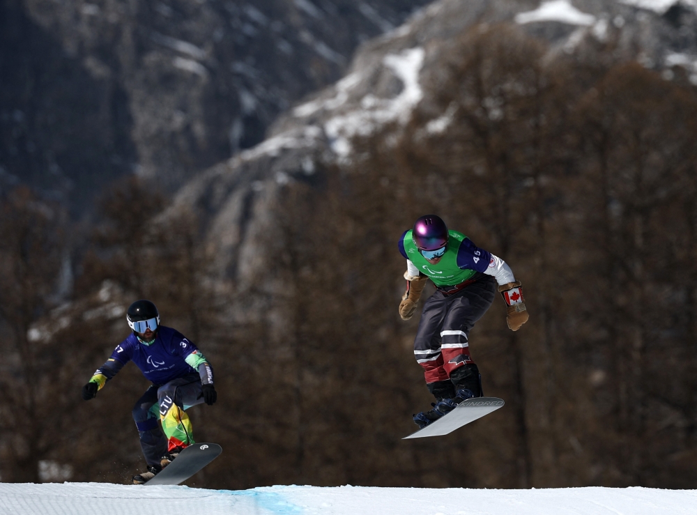 Canada’s Alex Massie and Lithuania’s Rapolas Micevicius compete during the men’s snowboard cross SB-LL2 quarter-final at the Milano Cortina 2026 Paralympics at the Cortina Para Snowboard Park in Cortina d’Ampezzo, Italy March 8, 2026. — Reuters pic