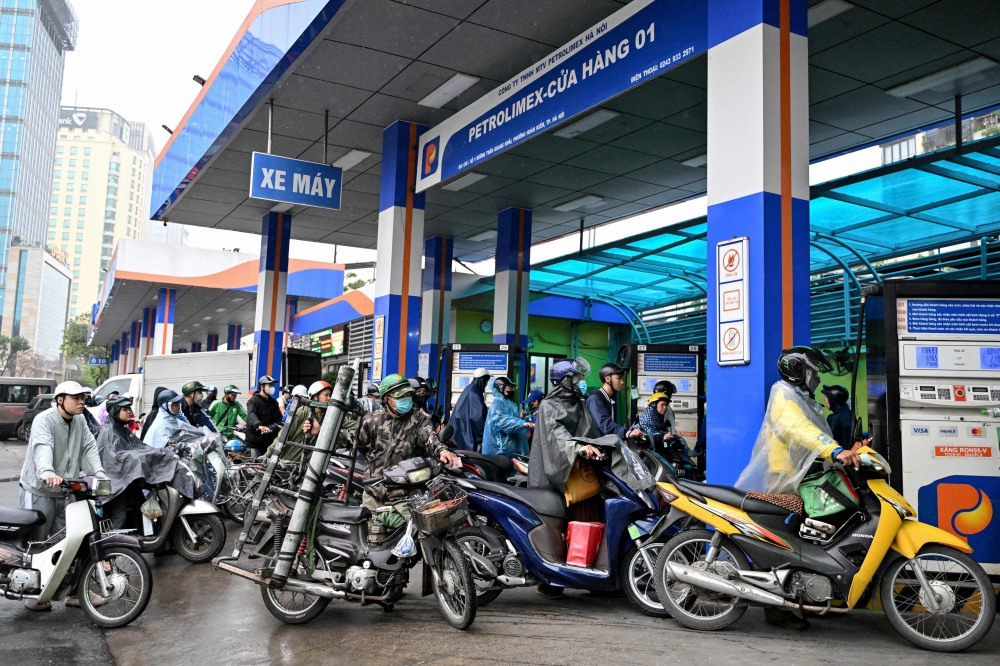 Drivers wait to pump gasoline into their vehicle at a gas station in Hanoi on March 9, 2026. — AFP pic