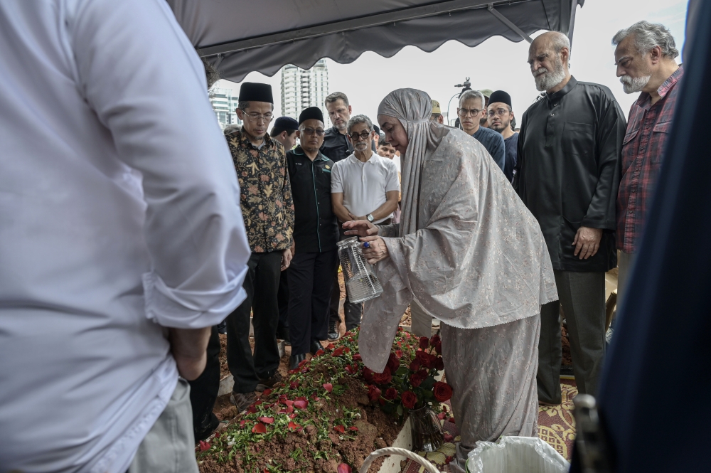 Family members sprinkled water and laid flowers at the grave of the late Royal Professor Tan Sri Dr Syed Muhammad Naquib Al-Attas, who was also a prominent thinker of contemporary Islamic civilization, at the Bukit Kiara Islamic Cemetery March 9, 2026. — Bernama pic