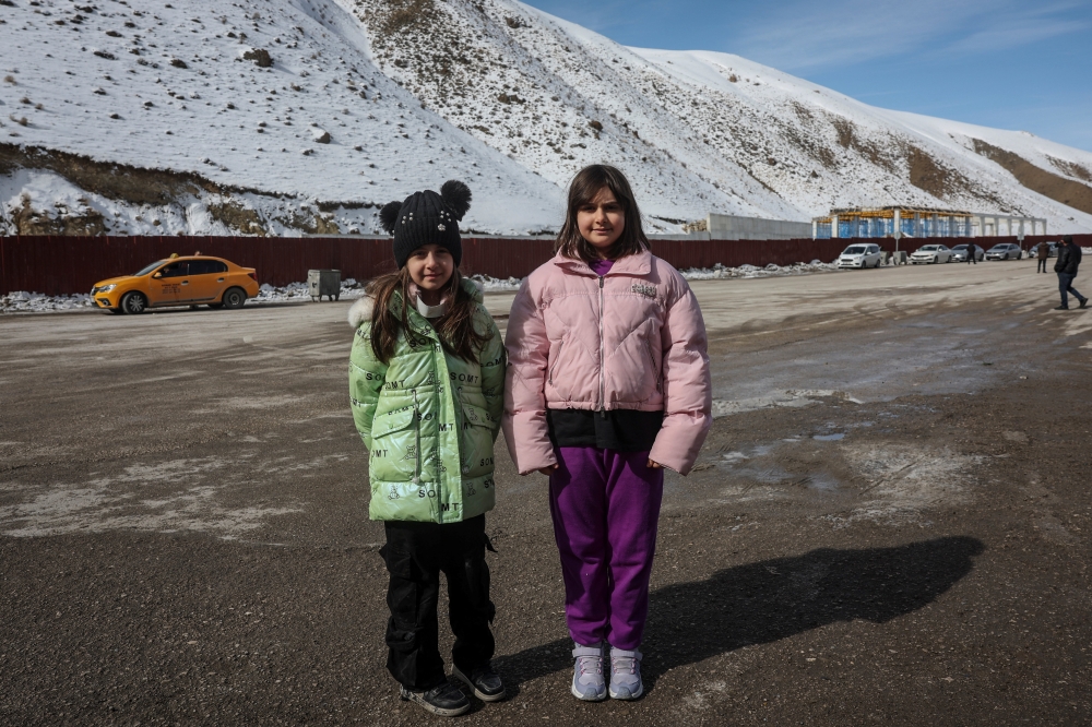 Sisters Shaylin Azizour, 9, and Celine Azizour, 11, pose for a portrait near the Kapikoy border gate after crossing from Iran into Turkiye, in Van province, Turkiye, March 6, 2026. The sisters crossed into Turkiye with their mother after travelling from Tehran. — Reuters pic