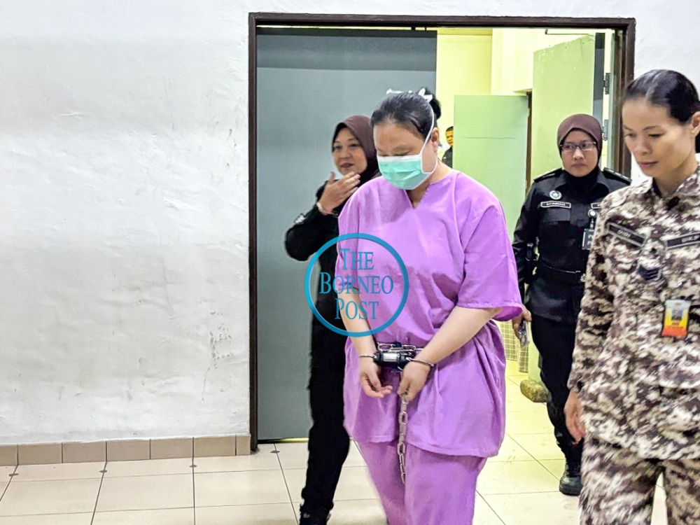 Seow is escorted at the Kuching Court Complex. — The Borneo Post pic