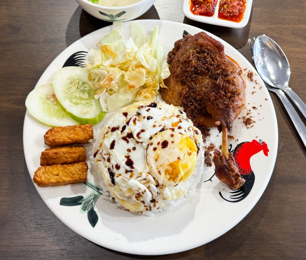 Mad Fried Bebek Signature combines crispy fried duck with rice, fried cabbage, a fried egg and fried ‘tempeh’. — Picture by Lee Khang Yi