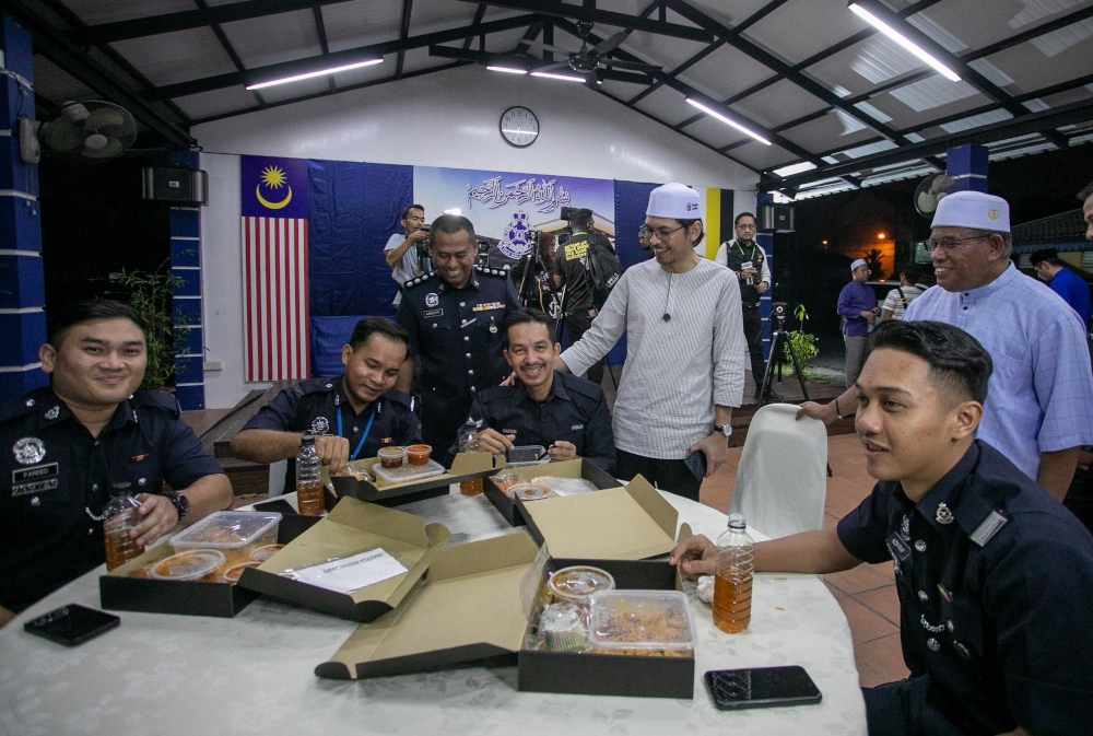 PKR Youth chief Muhammad Kamil Abdul Munim speaking with police personnel after distributing food packs for pre-dawn meals to frontliners at the Perak Police Contingent Headquarters in Ipoh, Perak. — Picture courtesy by Muhammad Kamil’s Media unit