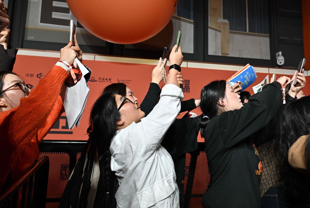 People react as Timothée Chalamet (unseen) arrives on the red carpet for screening of his film ‘Marty Supreme’ in Beijing March 10, 2026. — AFP pic