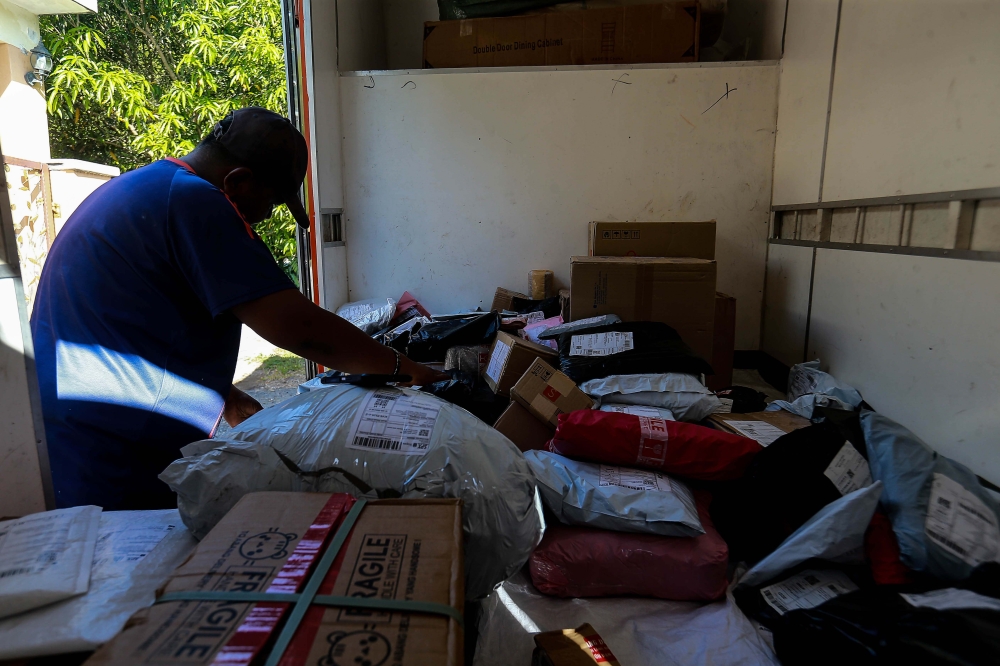 A delivery driver from a local courier company delivers parcels to its respective customers in Sungai Buloh, June 12, 2025. — Picture by Sayuti Zanudin