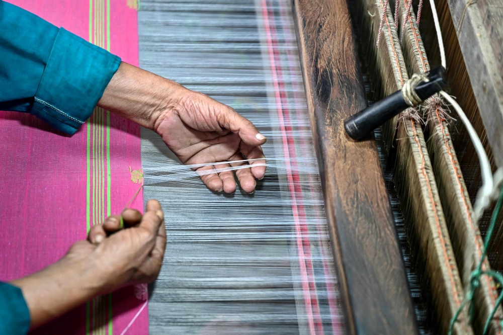 A Bangladeshi craftsman weaves fabric on a traditional handloom inside a workshop in Tangail on March 2, 2026. — AFP pic
