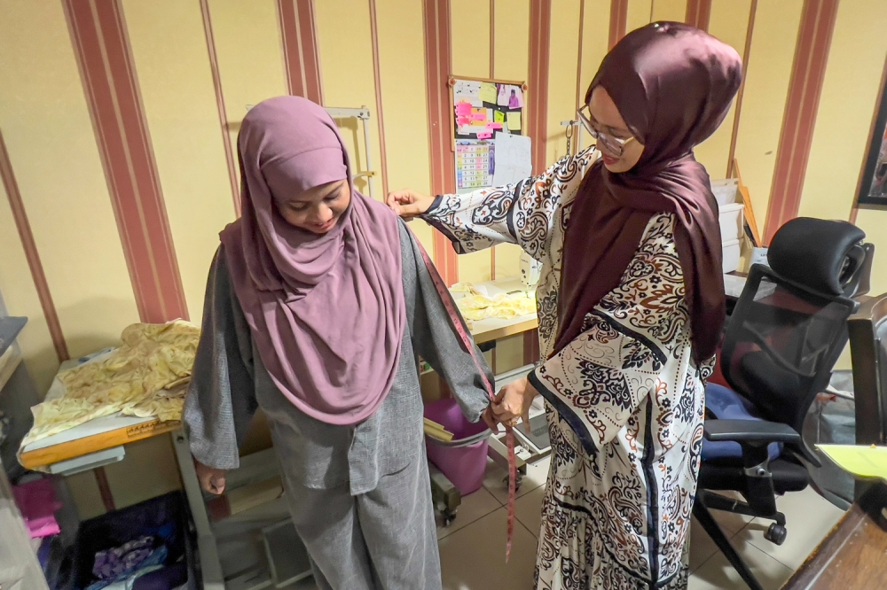 Alteration work keeps Hafiza just as busy as her tailoring orders as most of it brought in by customers whose online purchases did not quite work out. — Picture by Raymond Manuel