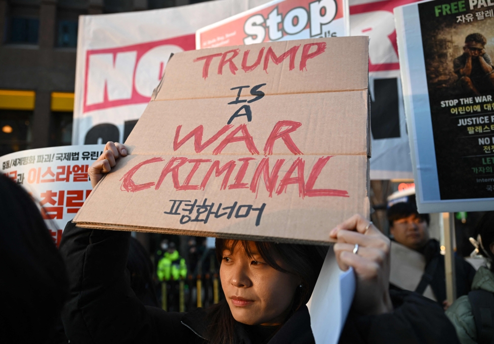 A woman carries a placard reading 