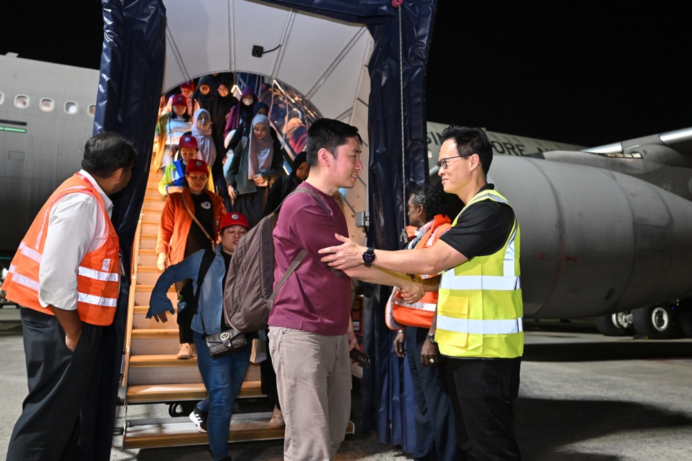Passengers evacuated from the Middle East disembark from a Republic of Singapore Air Force A330 Multi-Role Tanker Transport aircraft after arriving in Singapore early March 13. — Picture via Facebook/mindefsg