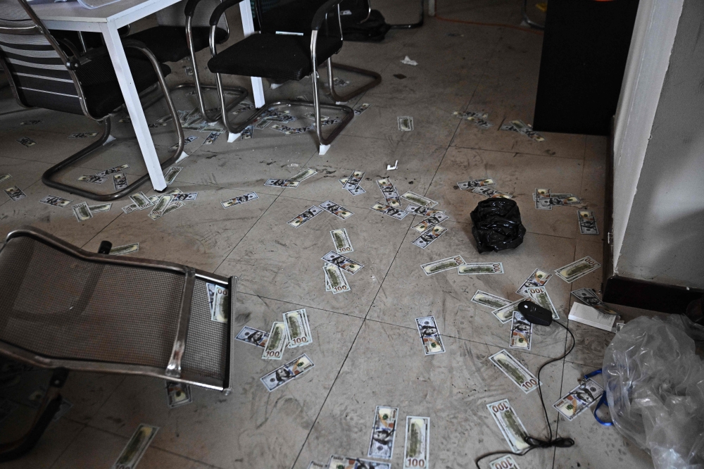 Fake US dollar bills lie on the floor inside an abandoned scam centre in O’Smach town on the Thai-Cambodian border on March 12, 2026. — AFP pic 