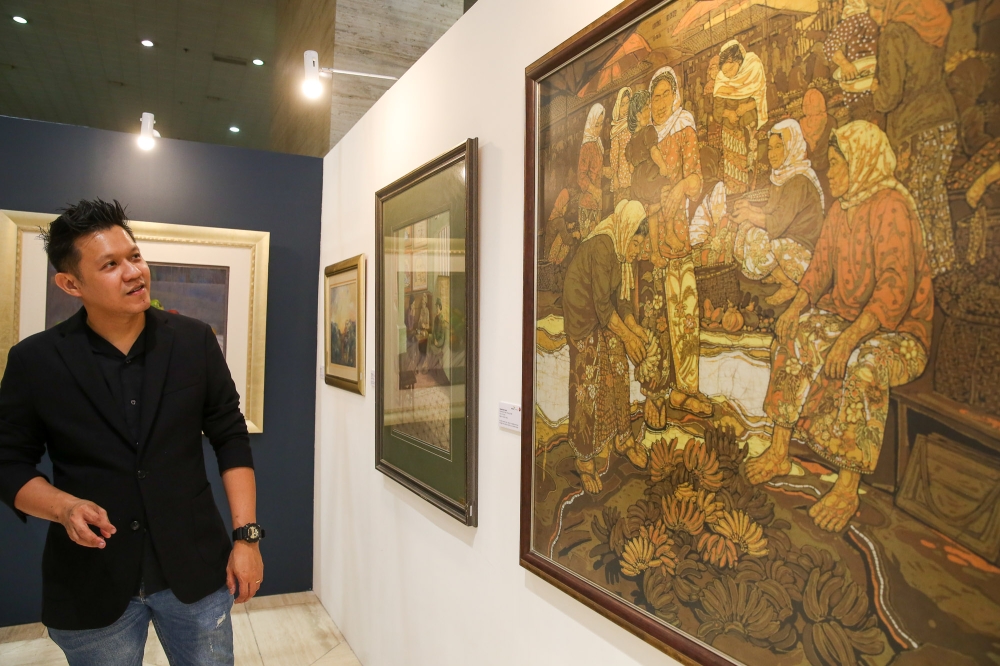 MACE curator Liu Cheng Hua presenting the late Kelantanese batik master Ismail Mat Hussin’s ‘Perempuan Pasar (Pisang)’, a batik on cotton fabric created in 1996. The artwork is awash in the warm, earthy tones that are a hallmark of Ismail’s style. — Picture by Choo Choy May