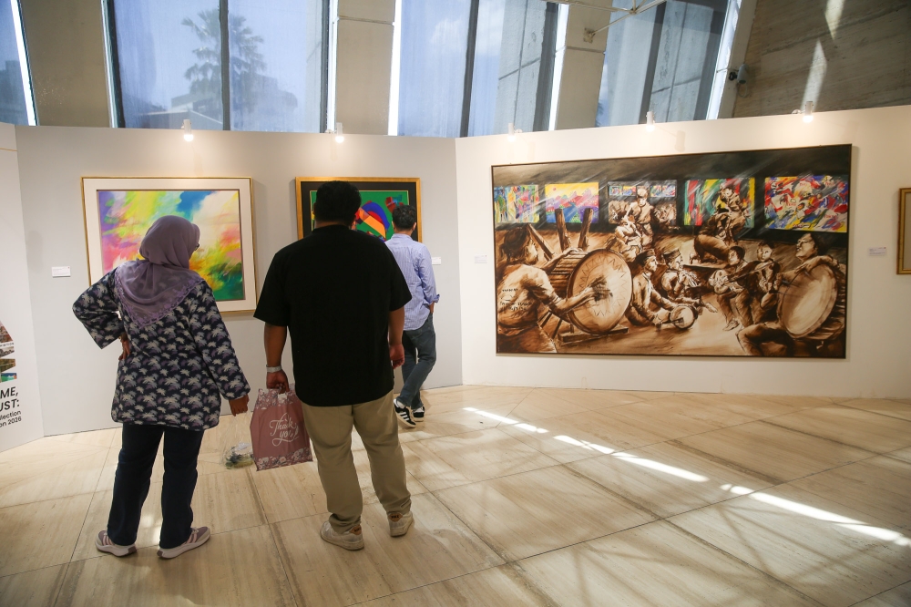 Visitors experiencing the artworks from Maybank’s collection at Balai Seni Maybank. ‘Malam Karyawan’ by Raja Azhar Idris, an oil on canvas produced in 1995, can be seen on the rightmost. — Picture by Choo Choy May