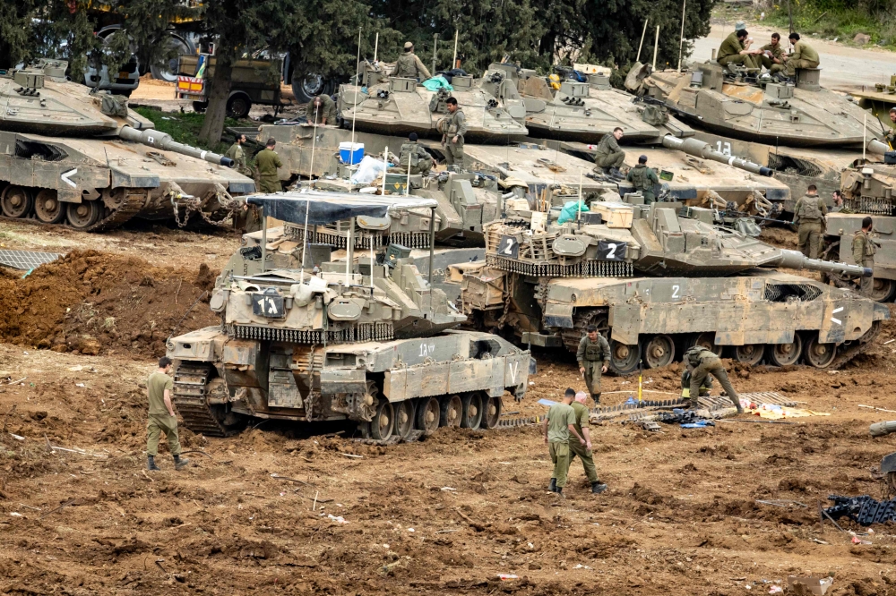 Israeli soldiers work on the belts for their tanks at a staging area in the Upper Galilee in northern Israel near the border with Lebanon on March 13, 2026. — AFP pic