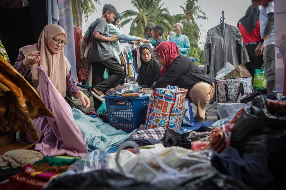 People browse piles of donated clothes for their next baju Raya at the Aidilfitri Free Market in Kuala Perlis, organised by NGO Grass Malaysia Perlis and Perlis SWCorp on March 9, 2026. — Bernama pic