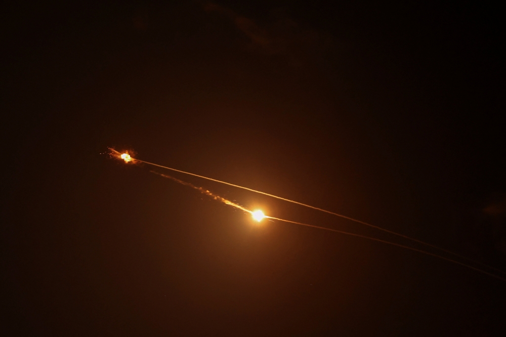 Streaks of light illuminate the sky during an interception attempt amid the US-Israeli conflict with Iran, as seen from Tel Aviv, Israel March 15, 2026. — Reuters pic  