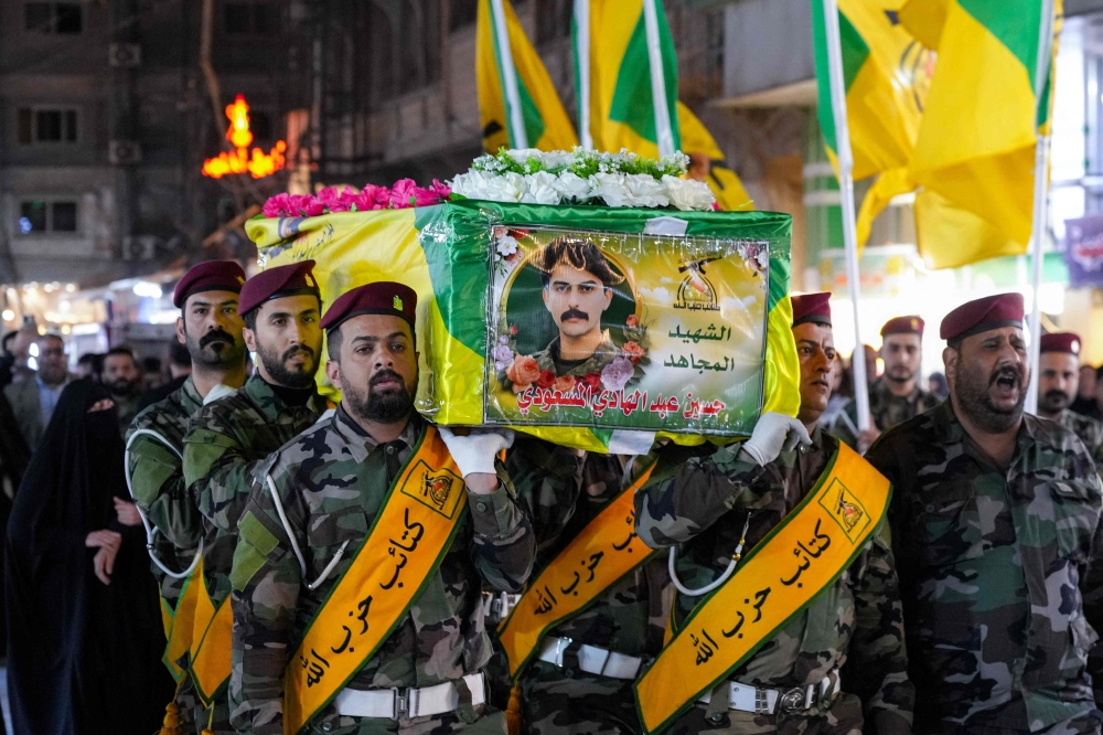 One of the caskets of two slain fighters from Iraq's pro-Iran paramilitary group Hezbollah Brigades (Kataeb Hezbollah), who were killed in a strike on their site in Baghdad's al-Jadriya area, is carried during their funeral at the shrine of Imam Ali in Iraq's central holy city of Najaf on March 14, 2026. — AFP pic 
