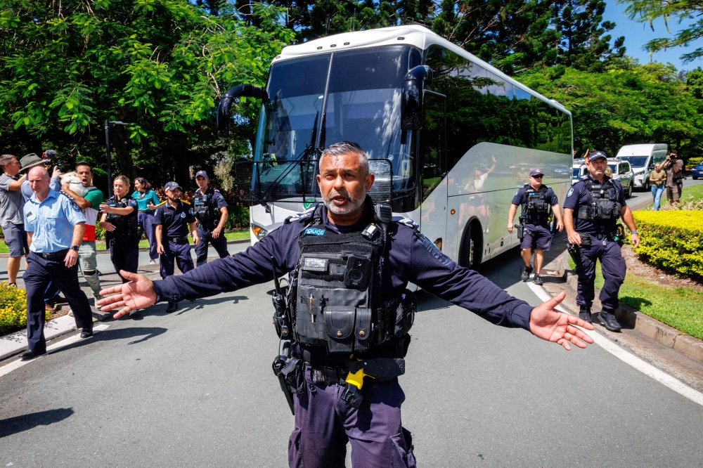 Police officers clear the road for a departing bus transporting members of the Iranian Women’s Asia Cup football team to the airport, after members of the Iranian community in Australia attempted to block its path, outside the Royal Pines Resort on the Gold Coast on March 10, 2026. Three more members of the Iranian women’s football team have left their asylum in Australia and decided to return home, Canberra said today. — AFP pic 