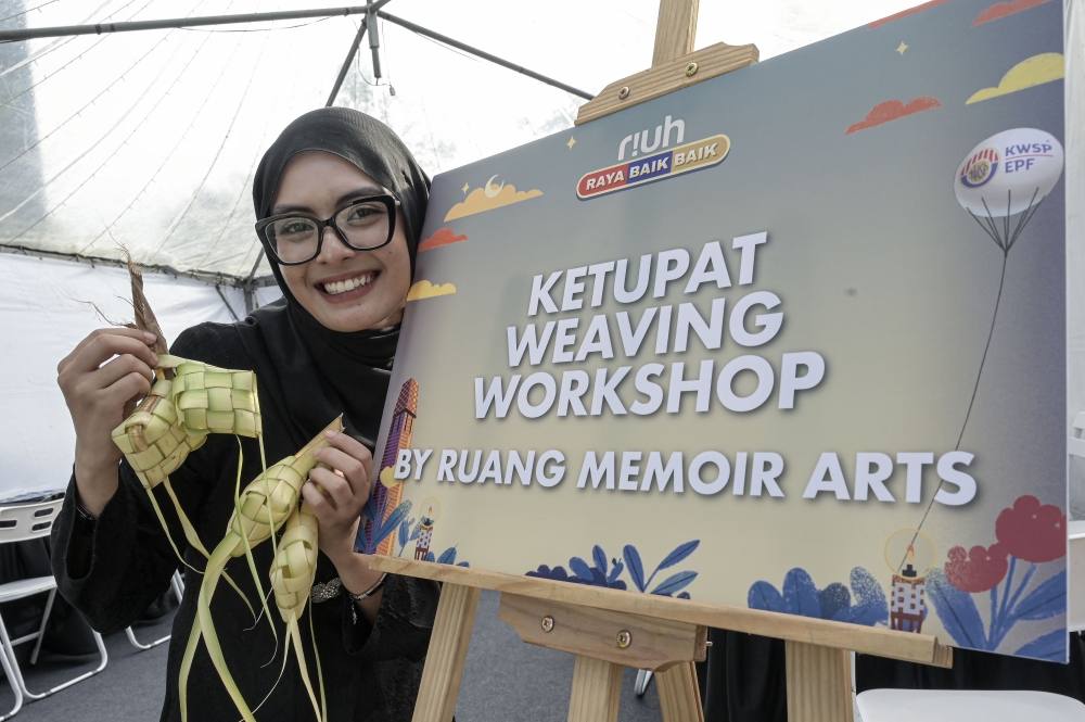 Nur Fatin Yasmin Firdaus at a ketupat weaving workshop during the Riuh Raya Baik Baik programme. — Bernama pic