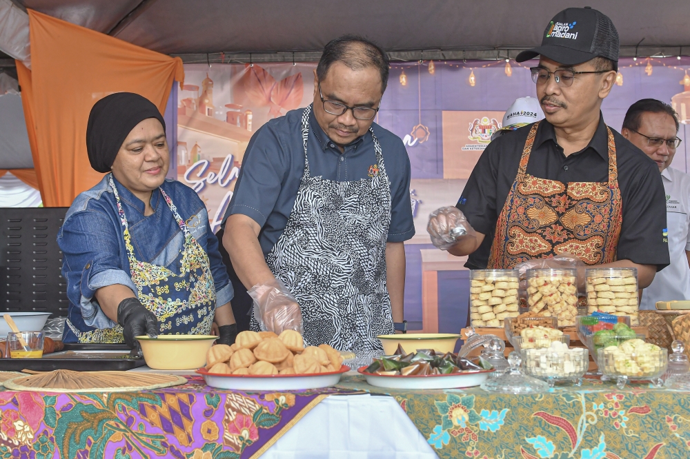 Federal Agricultural Marketing Authority (FAMA) Director-General Abdul Rashid Bahri (right) with Shah Alam Member of Parliament Azli Yusof (centre) during a demonstration of making Raya biscuits while attending the Semarak Syawal 1447 Launch Programme @ Selangor State Level Farmers' Market, Federal Territory of Kuala Lumpur and Putrajaya at the Shah Alam Stadium Farmers' Market March 15, 2026. — Bernama pic