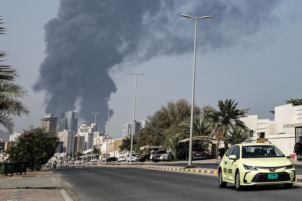 Smoke rises from the direction of a major UAE energy installation in Fujairah on March 14, 2026 hours after the US struck Iran’s Kharg Island. — AFP pic