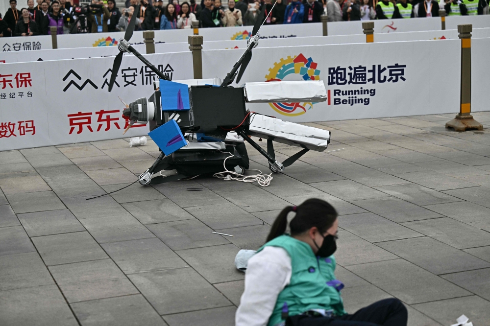 A robot loses control as it takes part in a half marathon race against humans in Beijing, China. Some insurers are already embracing AI risk, others say ‘no coverage’ to rogue robots. — AFP pic
