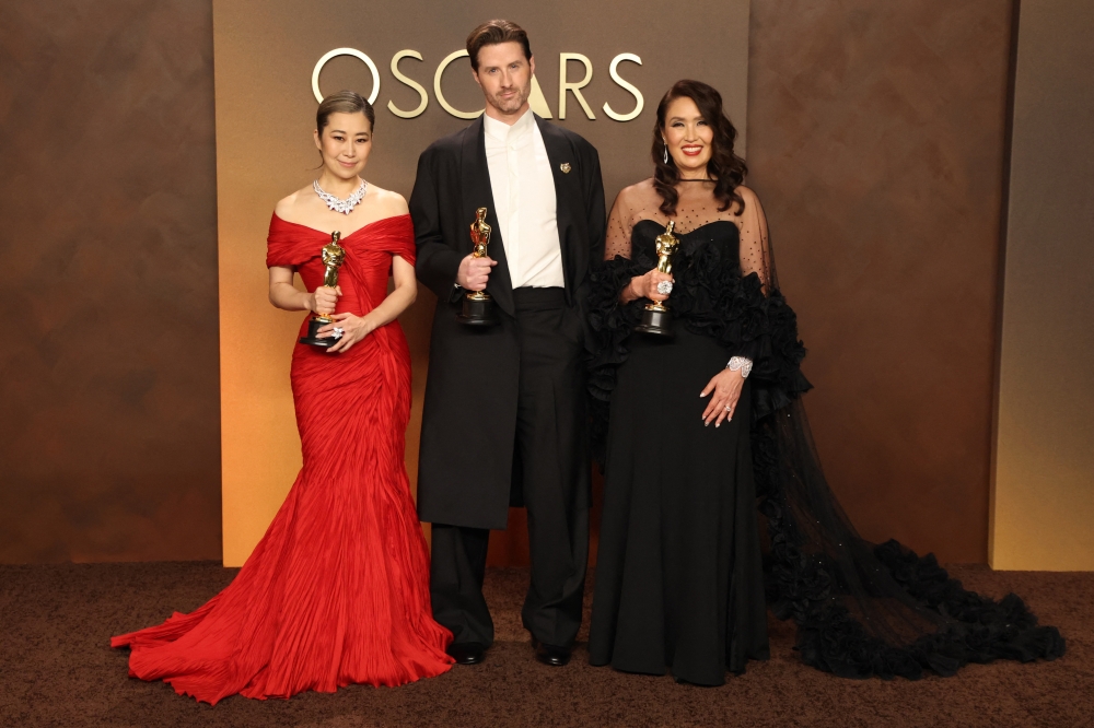 Maggie Kang, Chris Appelhans and Michelle L.M. Wong pose with the Oscar for Best Animated Feature Film for ‘KPop Demon Hunters’ in the Oscars photo room at the 98th Academy Awards in Hollywood, Los Angeles, California, US, March 15, 2026. — Reuters pic