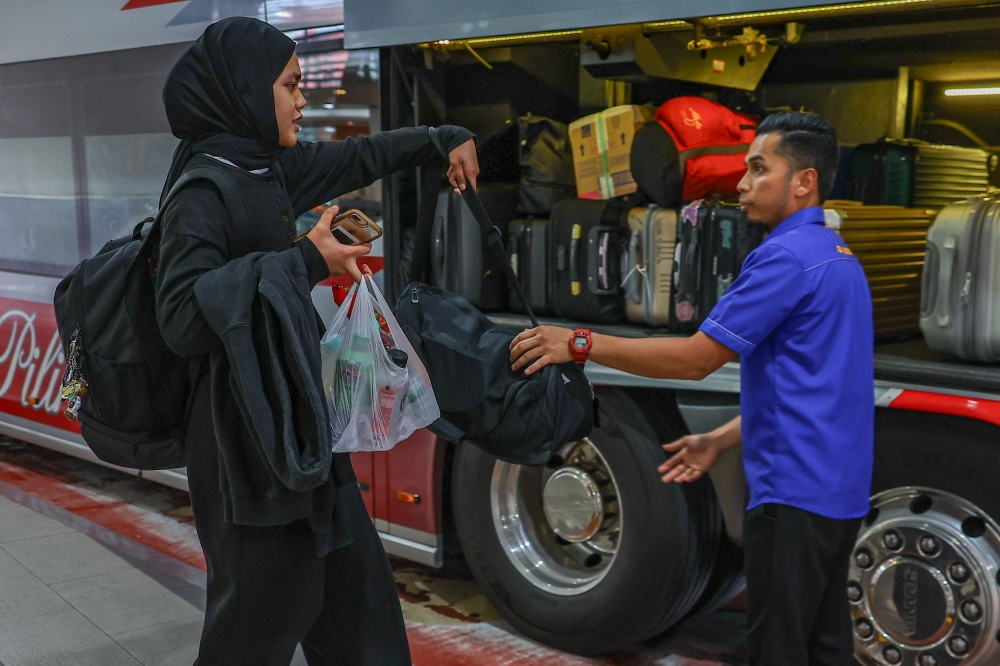 A passenger loads her luggage onto a bus at at Terminal Bersepadu Selatan in Kuala Lumpur March 28, 2025. — Bernama pic