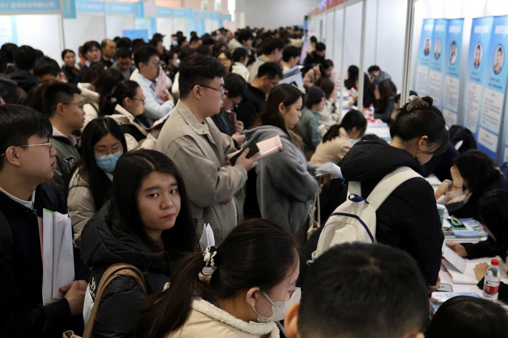 People line up at career guidance booths during a job fair in Beijing, China March 14, 2026. — Reuters pic
