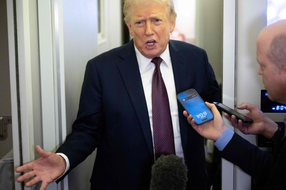 US President Donald Trump speaks with reporters aboard Air Force One during a flight from West Palm Beach, Florida, to Joint Base Andrews in Maryland, on March 15, 2026. — AFP pic