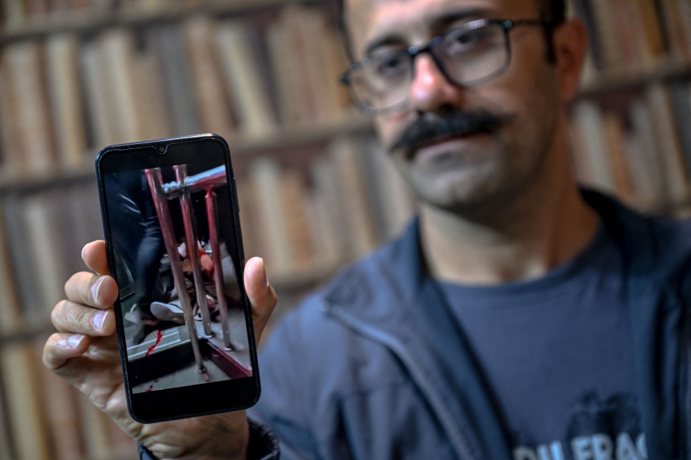 Farhad Sheikhi, an Iranian Kurd who the 2022 joined anti-government protests, shows images of the protests in Iran during an interview in Sulaimaniyah, Iraq on March 12, 2026. — AFP pic