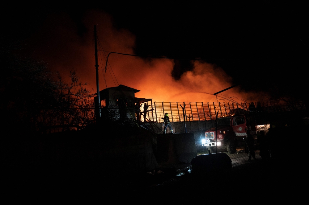 Afghan firefighters and Taliban security personnel work to extinguish fires after Pakistani airstrikes allegedly hit the Secondary Rehabilitation Services Centre in Kabul on March 16, 2026. — AFP pic 