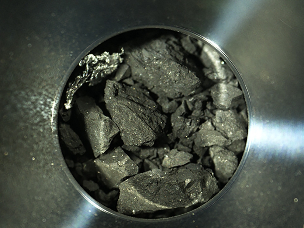 This handout photograph released by the Japan Aerospace Exploration Agency (JAXA) on December 24, 2020 shows samples of soil from the asteroid Ryugu, inside C compartment of the capsule collected by the Hayabusa-2 space probe, at JAXA Sagamihara Campus in Sagamihara, Kanagawa prefecture. — Handout via AFP