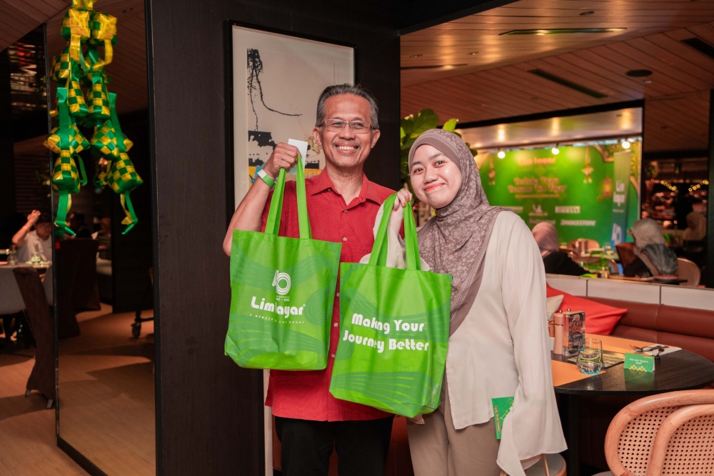 Guests pose with Lim Tayar goodie bags during the company’s third annual ‘buka puasa’ appreciation dinner in Kuala Lumpur. — Picture courtesy of Lim Tayar