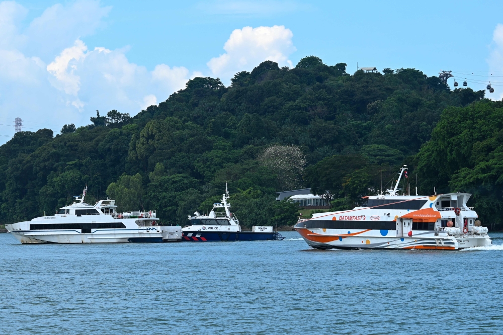 File photo of ferries departing Singapore for Batam, Indonesia. Passengers on the busy route will now pay an additional fuel surcharge as global oil prices climb. — AFP pic