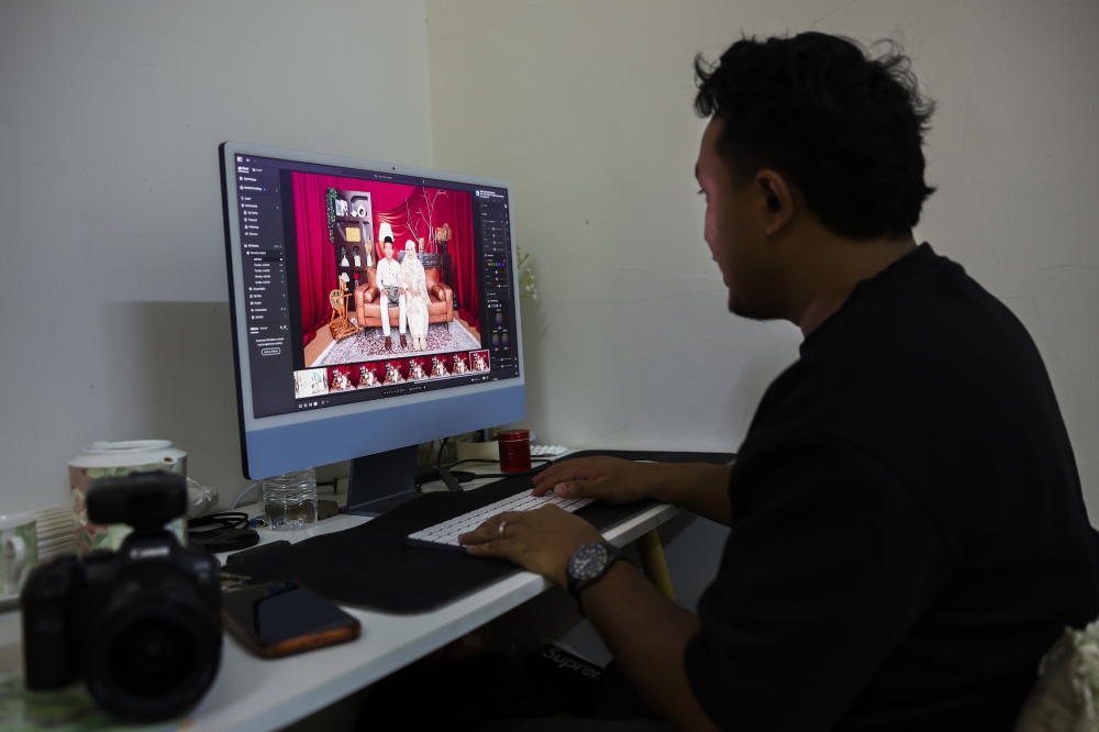 Photographer Muhammad Shahrul Eizwan Mohd Sukri edits a client’s photos at his studio in Kuantan March 17, 2026. — Bernama pic